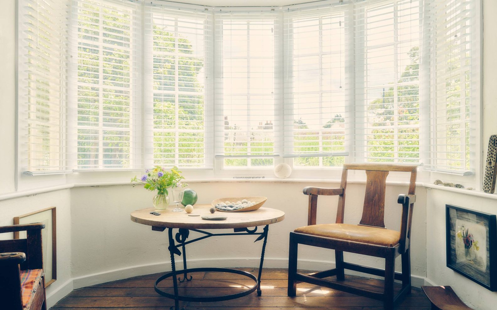 A sunlit bay window with a small table and flowers inside Kettle's Yard Cambridge
